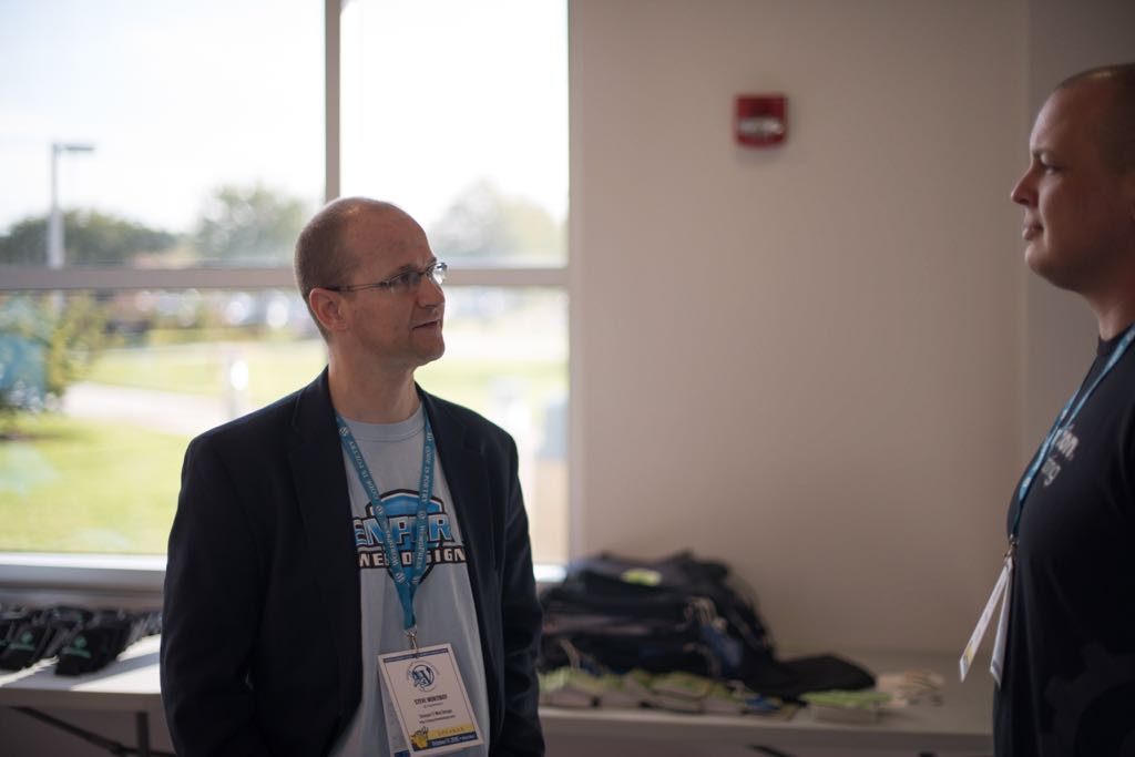 Photo of Steve Mortiboy speaking to an attendee at WordCamp Hampton Roads 2015
